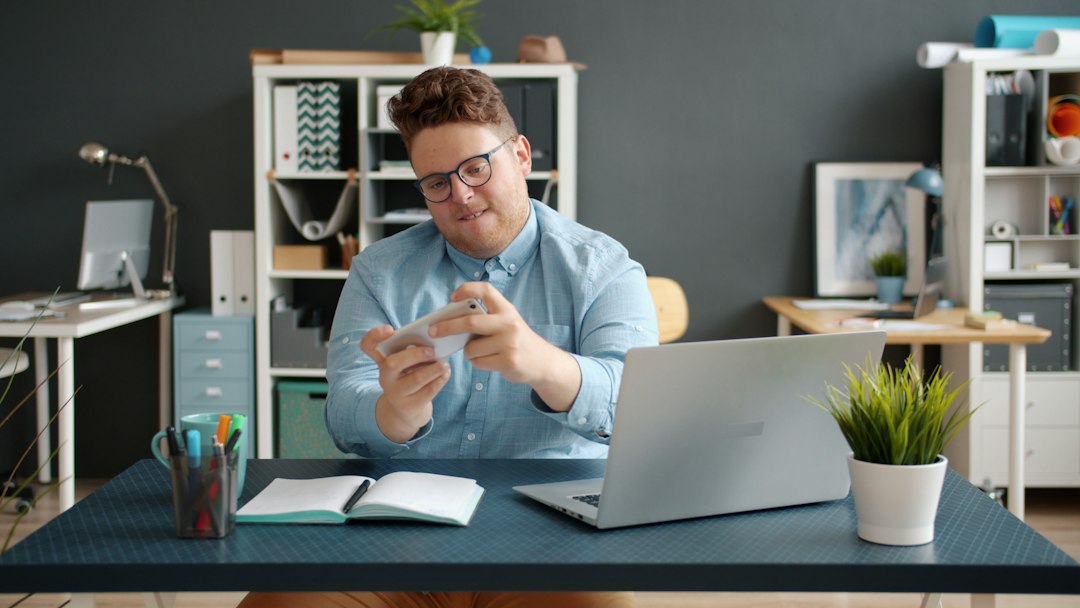 A person sits at a clean, organized desk with a notebook and calculator, diligently planning their finances to save for a down payment on a house.